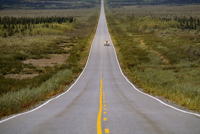 Truck driving down a long, straight road in a rural area, Alaska Highway, Alaska, USA; Alaska, United States of America, by Michael Melford / Design Pics