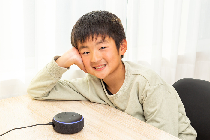 A boy talking to a smart speaker