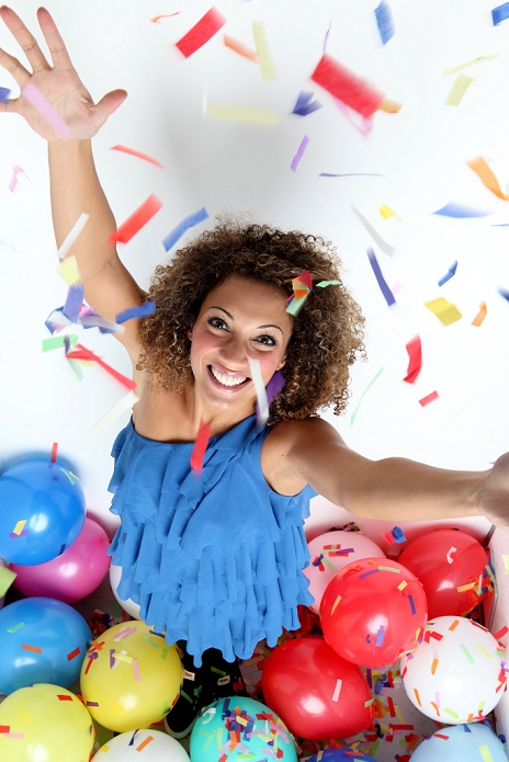 Smiling woman in confetti and balloons
