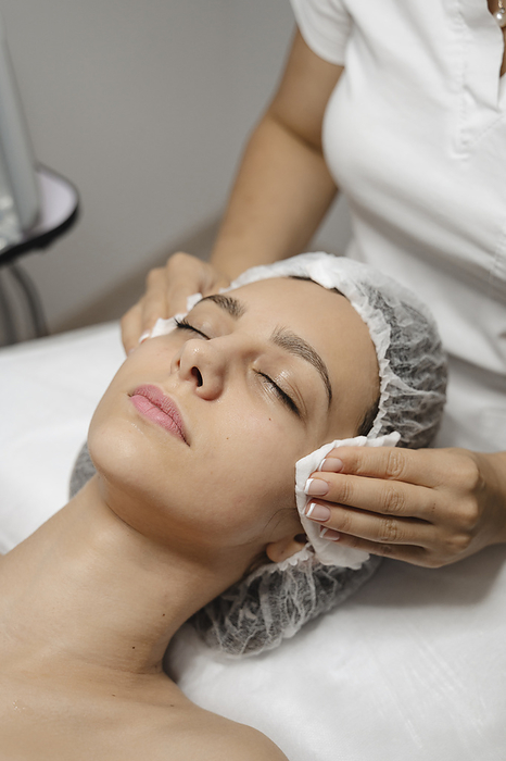 Cosmetologist doing skin care treatment on woman's face