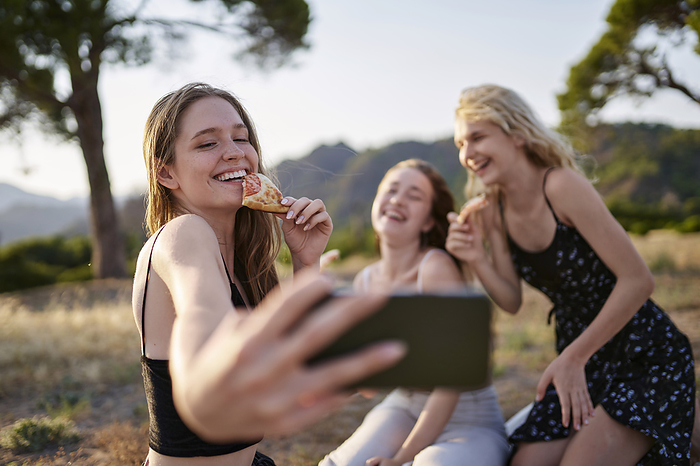 Happy friends taking selfie on smart phone at weekend