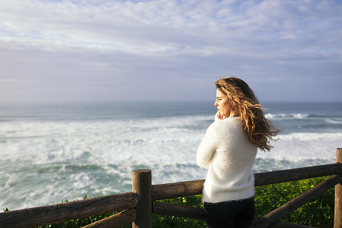 Young woman enjoying sunlight by sea
