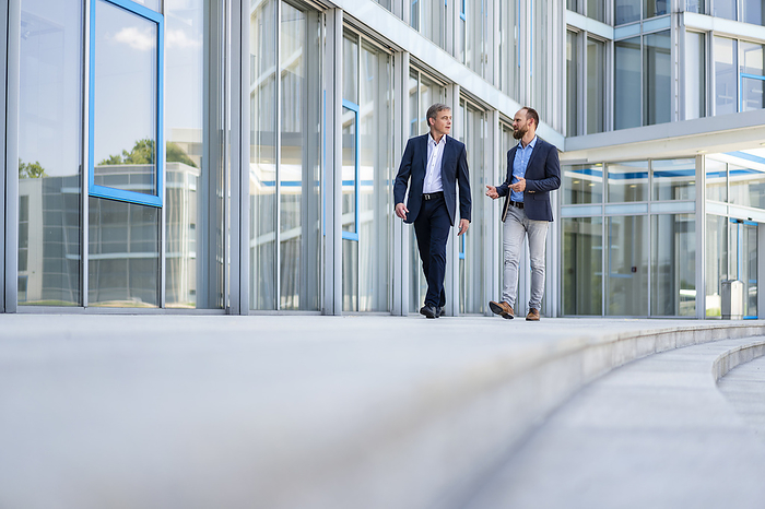 Two managers walking in modern building talking business