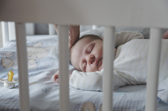 Baby girl sleeping in crib at home