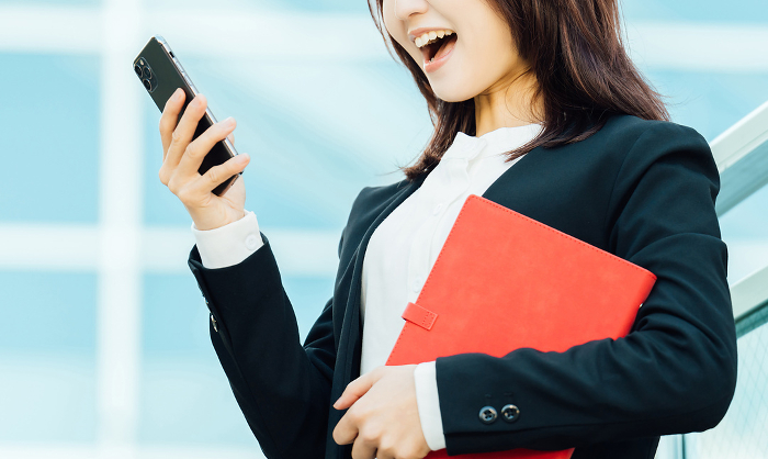 Businesswoman delighted to see her smartphone screen