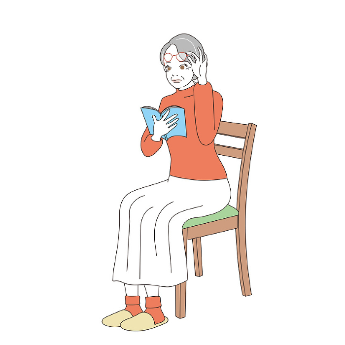 Elegant senior woman sitting in a chair reading a book