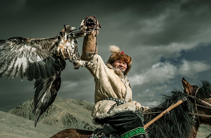 Mongolian eagle hunter, Kazakhs on horseback with trained eagle, Bajan-Ölgii province, Mongolia, Asia, by Bayar Balgantseren