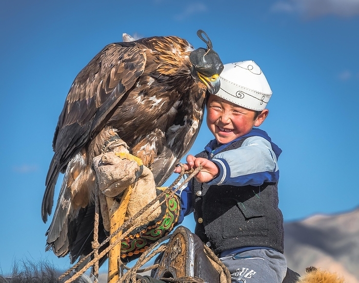 Young eagle hunter, happy boy with trained eagle, Bajan-Ölgii province, Mongolia, Asia, by Bayar Balgantseren