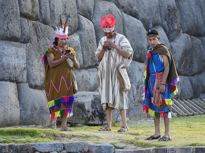 Inti Raymi, Festival of the Sun, performers check their cell phones after the show, Inca Sacsayhuamán ruins complex, Cusco, Peru, South America, by Peter Giovannini