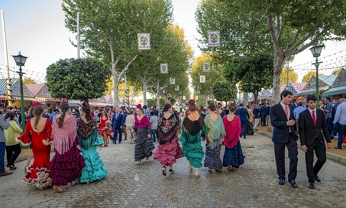 Celebrating Spaniards in traditional dress in front of marquees, woman in colourful flamenco dresses, casetas, decorated street, Feria de Abril, Sevilla, Andalusia, Spain, Europe, by Mara Brandl