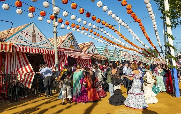 Celebrating Spaniards in traditional dress in front of marquees, casetas, decorated street, Feria de Abril, Sevilla, Andalusia, Spain, Europe, by Mara Brandl
