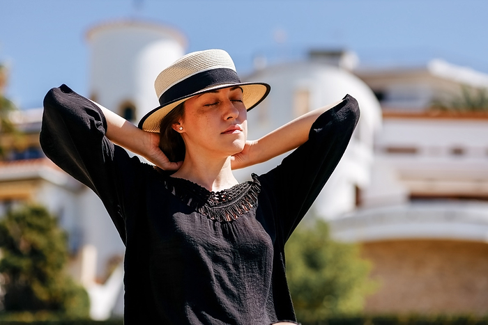 Portrait of serene female with hat in the summer day., by Cavan Images / Diana Plechkov