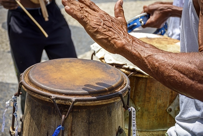 Musicians playing traditional instruments used in capoeira, a mix of fight and dance from Afro-Brazilian culture in the streets of Pelourinho in Salvador, Bahia, Brasil, by Fred Pinheiro