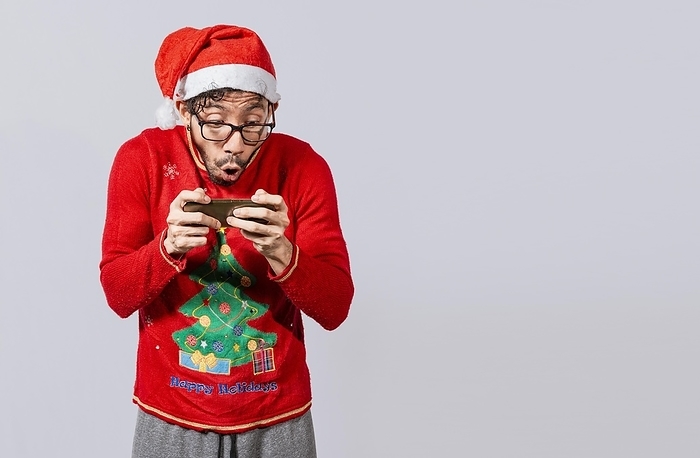 Amazed man looking at a christmas offer online, Guy looking at a christmas promo on phone. Online christmas special offers concept, Surprised people watching a christmas promotion on the phone, by Isai Hernandez
