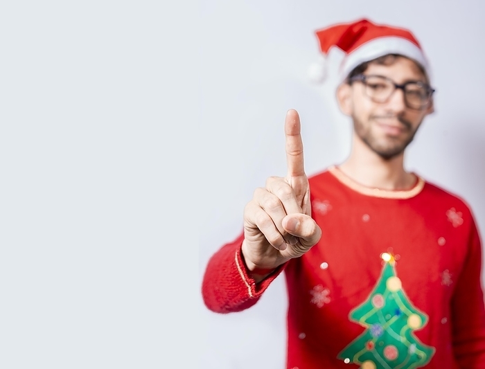 Man in christmas hat counting number one with finger. Man in christmas costume counting number one with finger. Concept of man in christmas costume counting number one isolated, by Isai Hernandez