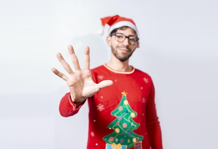 Man in christmas hat counting number five with fingers. Man in christmas costume counting number five with fingers. Concept of man in christmas costume counting number five isolated, by Isai Hernandez
