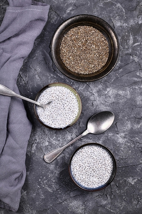 Top view of Chia seed pudding made with dry seeds soaked in milk in small bowls, by Firn