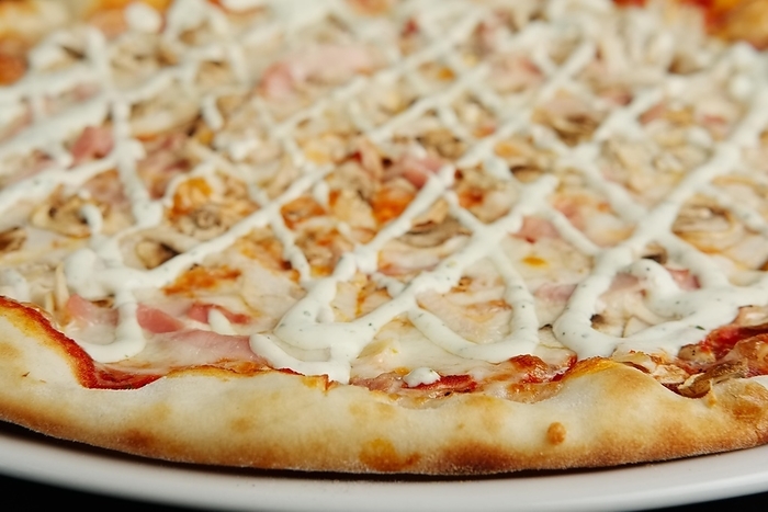 Closeup view of pizza with chicken fillet, champignon, bacon and cheese