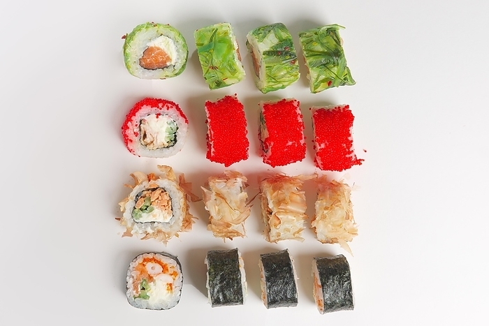 Set of rolls with smoked salmon, eel, chukka salad and flying fish roe on white background. Top view