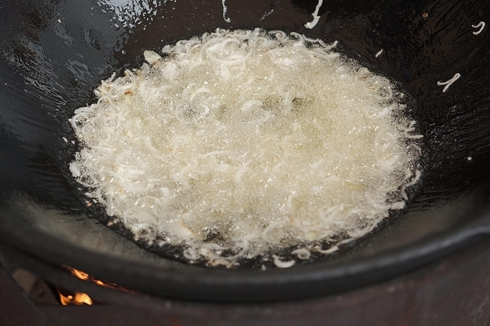 Frying onion in oil in cauldron. The making of pilaf, step by step