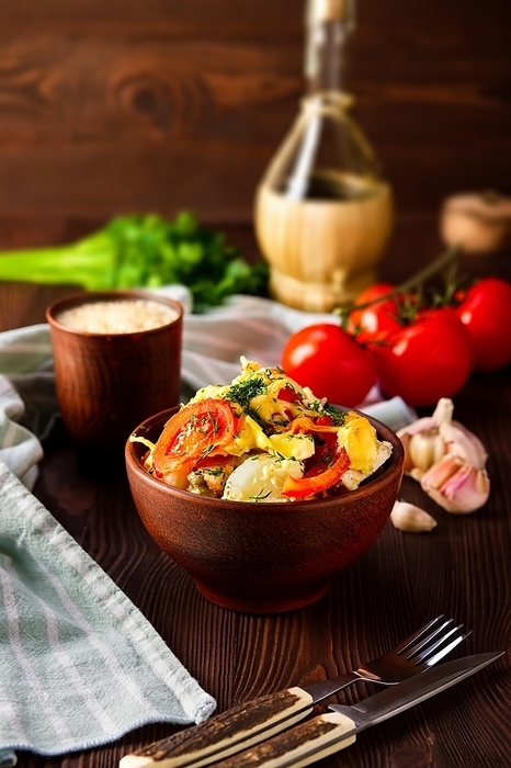 Country stew with meat, potato, tomato onion and cheese in clay bowl on rustic table served for dinner