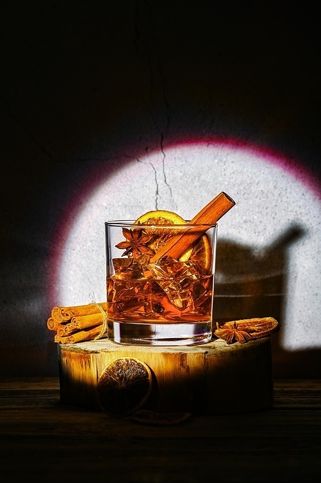 Cold cocktail with brandy and orange liquor, cinnamon and star anise on wooden block