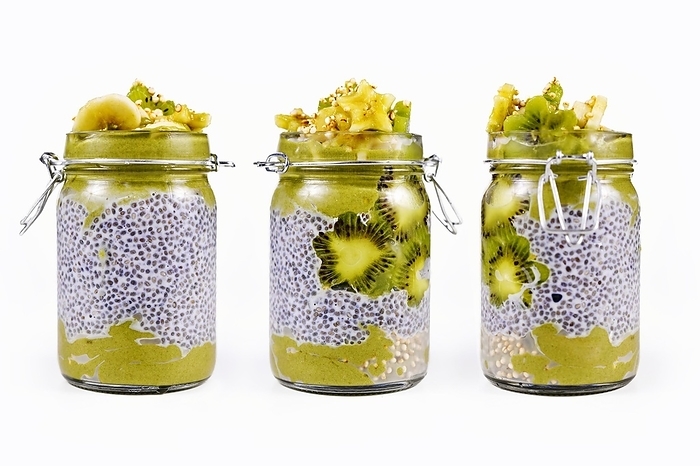 Layered green fruit smoothie in glass with chia seed pudding topped with star shaped banana and kiwi slices, view from different sides