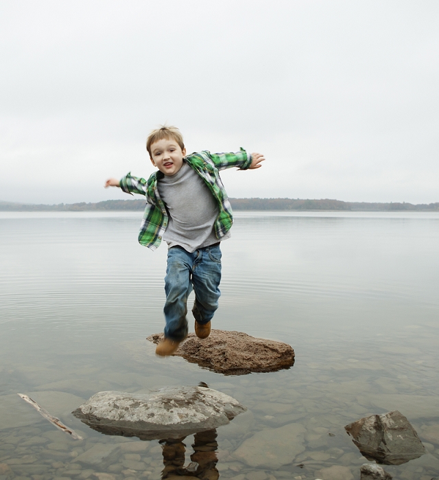 A day out at Ashokan lake. A boy jumping across stepping stones.