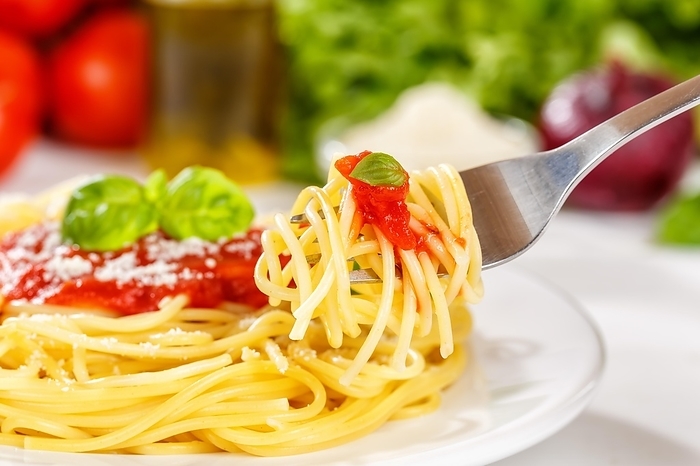 Eat spaghetti with fork Italian pasta lunch dish with tomato sauce in Stuttgart, Germany, Europe