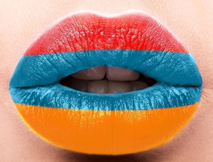 Female lips close up with a picture of the flag of Armenia. Blue, Orange, red
