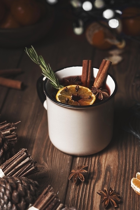 Christmas hot drink mulled wine on wooden background with cinnamon, cloves, spices