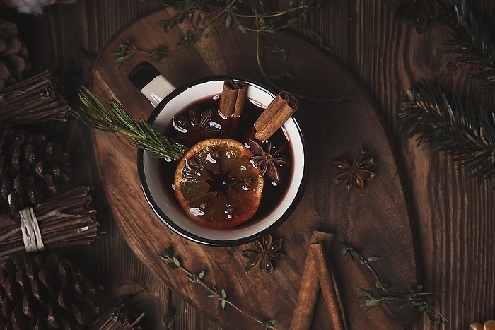 Christmas hot drink mulled wine on wooden background with cinnamon, cloves, spices