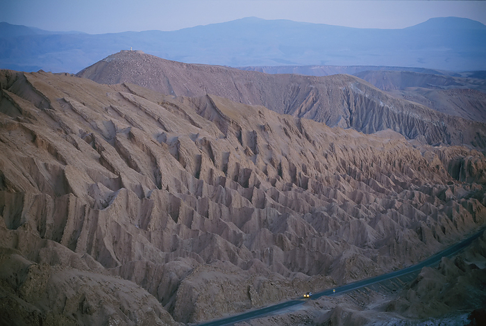 The desert dwarfs the one road from Calama to San Pedro de Atacama, the Paso de Jama Highway in the Atacama Desert of Chile; Chile, by Joel Sartore Photography / Design Pics