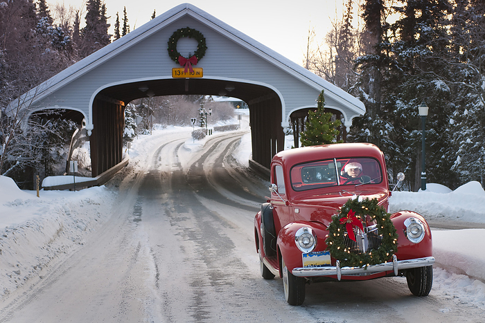 Man Driving A Vintage 1941 Ford Pickup Through A Covered Bridge With A Christmas Wreath On The Grill And A Tree In The Back During Winter In Southcentral, Alaska, by Jim Lavrakas / Design Pics