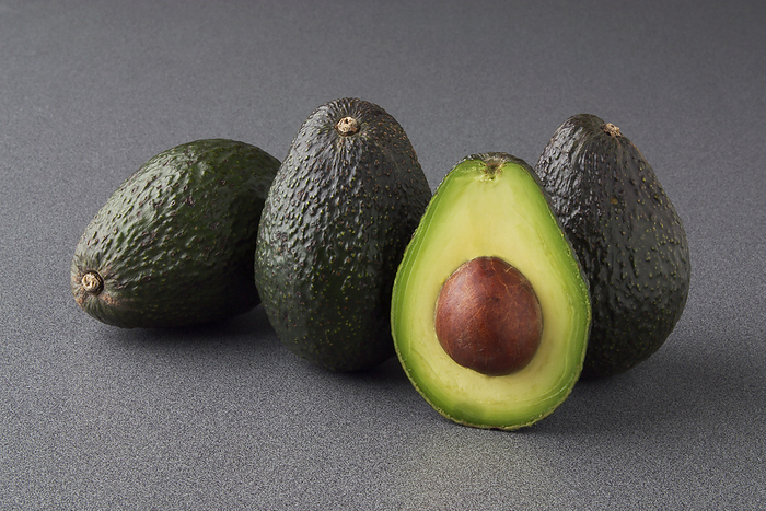 Agriculture - Haas avocados in a studio setting, one sliced in half., by Ed Young / Design Pics
