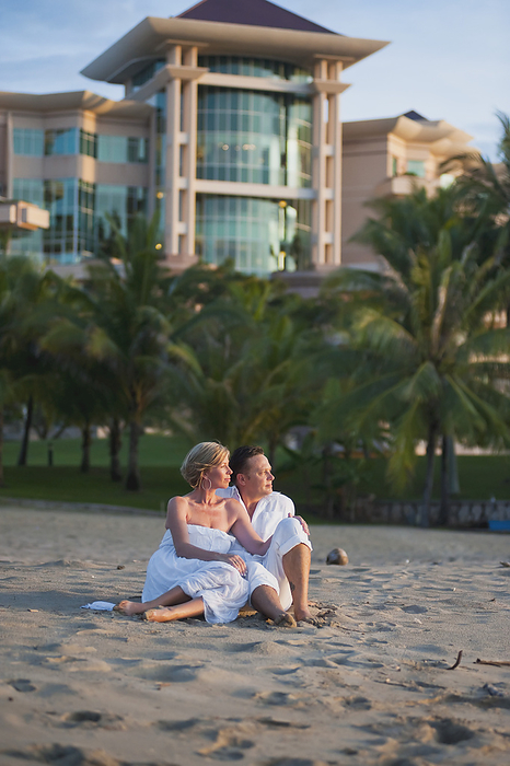 Brunei A Couple Sitting On The Beach At The Empire Hotel And Country Club  Bandar Seri Begawan, Brunei, by David Kirkland   Design Pics