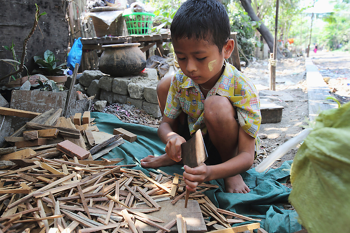 Yangon, Myanmar A Small Boy Works Chopping Sticks For Firewood, With A Large Meat Cleaver, Yangon, Myanmar  Ayeyarwady, Burma, by Jim Holmes   Design Pics