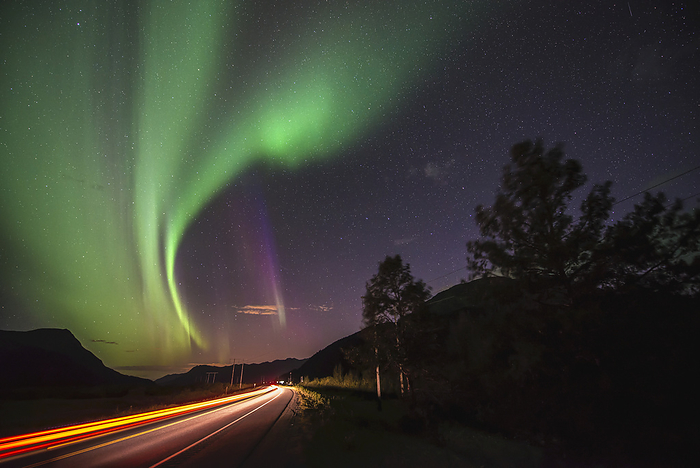 A Car Passes By On The Seward Highway South Of Girdwood, Alaska, As The Aurora Borealis Dance Overhead., by Carl Johnson / Design Pics