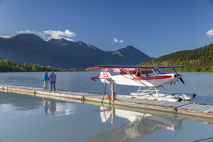 America A Woman And A Man Stand On A Dock Where A Float Plane Is Docked, Trail Lake Float Plane Base, Moose Pass, Kenai Peninsula, Southcentral Alaska, USA, by Kevin G. Smith   Design Pics