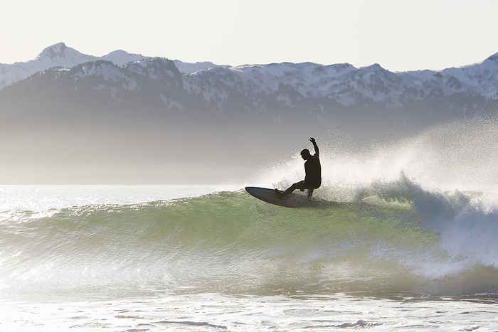 America Surfer riding a wave on the Kenai Peninsula Outer Coast, South central Alaska  Alaska, United States of America, by Scott Dickerson   Design Pics