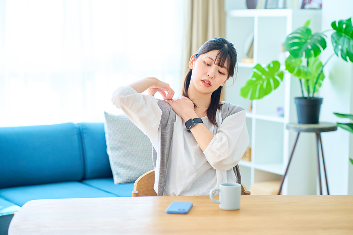 A young Japanese woman stretches in a casual space (People)
