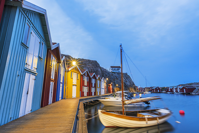 Colorful fishing huts with wooden boat moored at the jetty at dusk, Smogen, Bohuslan, Vastra Gotaland, West Sweden, Sweden, Scandinavia, Europe Colorful fishing huts with wooden boat moored at the jetty at dusk, Smogen, Bohuslan, Vastra Gotaland, West Sweden, Sweden, Scandinavia, Europe, by Paolo Graziosi