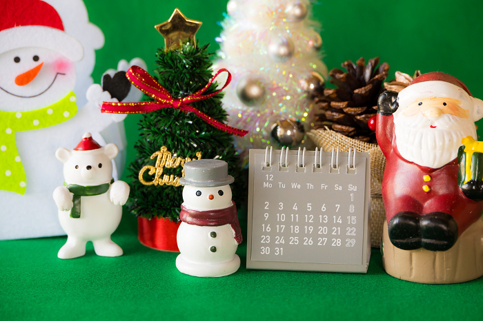 Christmas-inspired sundries on a green background (calendar is 2024)
