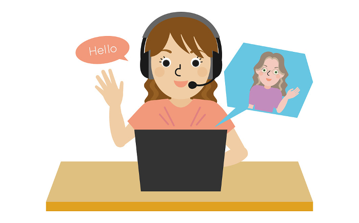 Front view of a Japanese woman wearing headphones and speaking English with a native English speaking teacher online.
