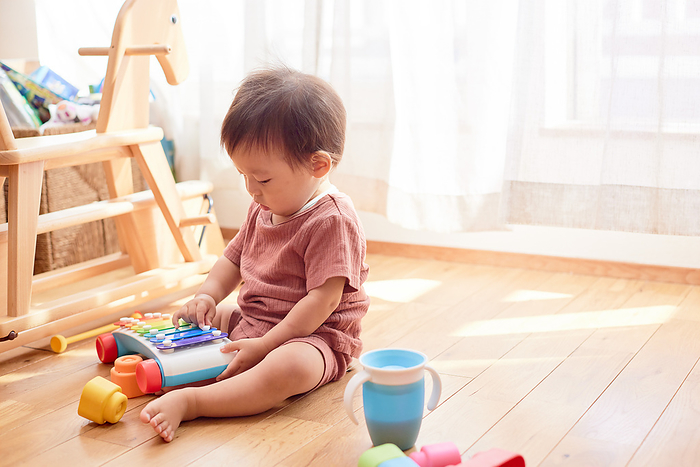 Japanese baby playing with toy xylophone
