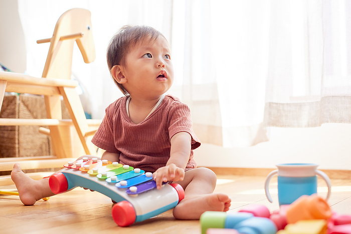 Japanese baby playing with toy xylophone