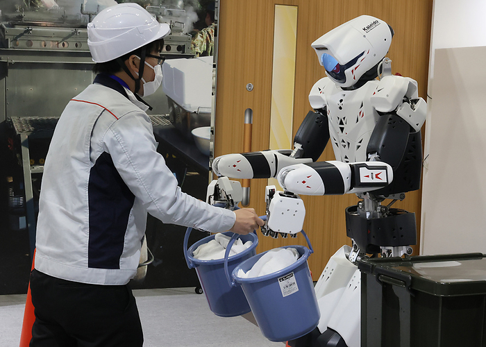 Robot makers display their katest products at the International Robot Exhibition November 30, 2023, Tokyo, Japan   Japan s Kawasaki Heavy Industries demonstrates a humanoid robot  RHP Kaleido  to receive buckets from a human at the International Robot Exhibition 2023 in Tokyo on Thursday, November 30, 2023.    photo by Yoshio Tsunoda AFLO 