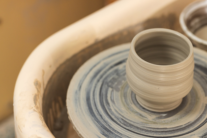 Close up of clay bowl on potter's wheel in pottery studio. Pottery, ceramics, handmade, local business, hobbies and craft.