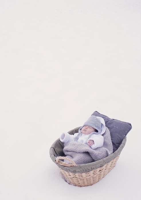 Baby sleeping in bassinet in snow