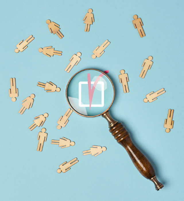 Wooden men and a magnifying glass on a blue background. Recruitment concept, search for talented and capable employees, career growth, flat lay Wooden men and a magnifying glass on a blue background. Recruitment concept, search for talented and capable employees, career growth, flat lay